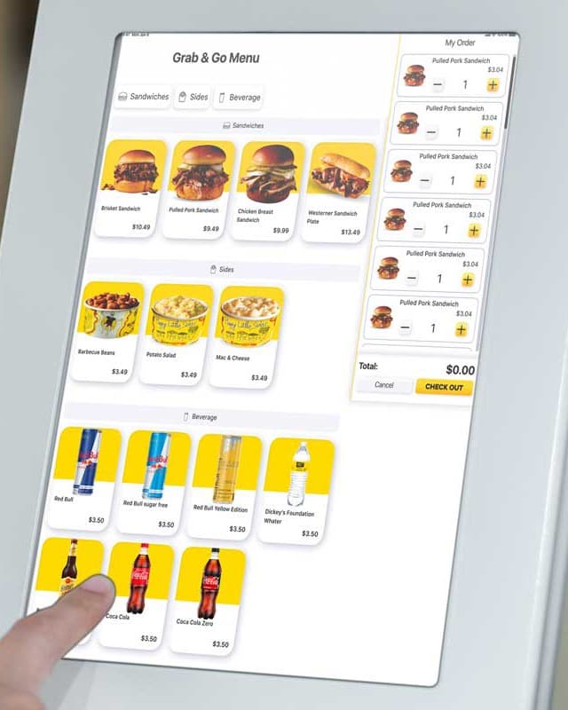 Guest tapping a self-service kiosk showing a grab-and-go menu of sandwiches, sides and drinks